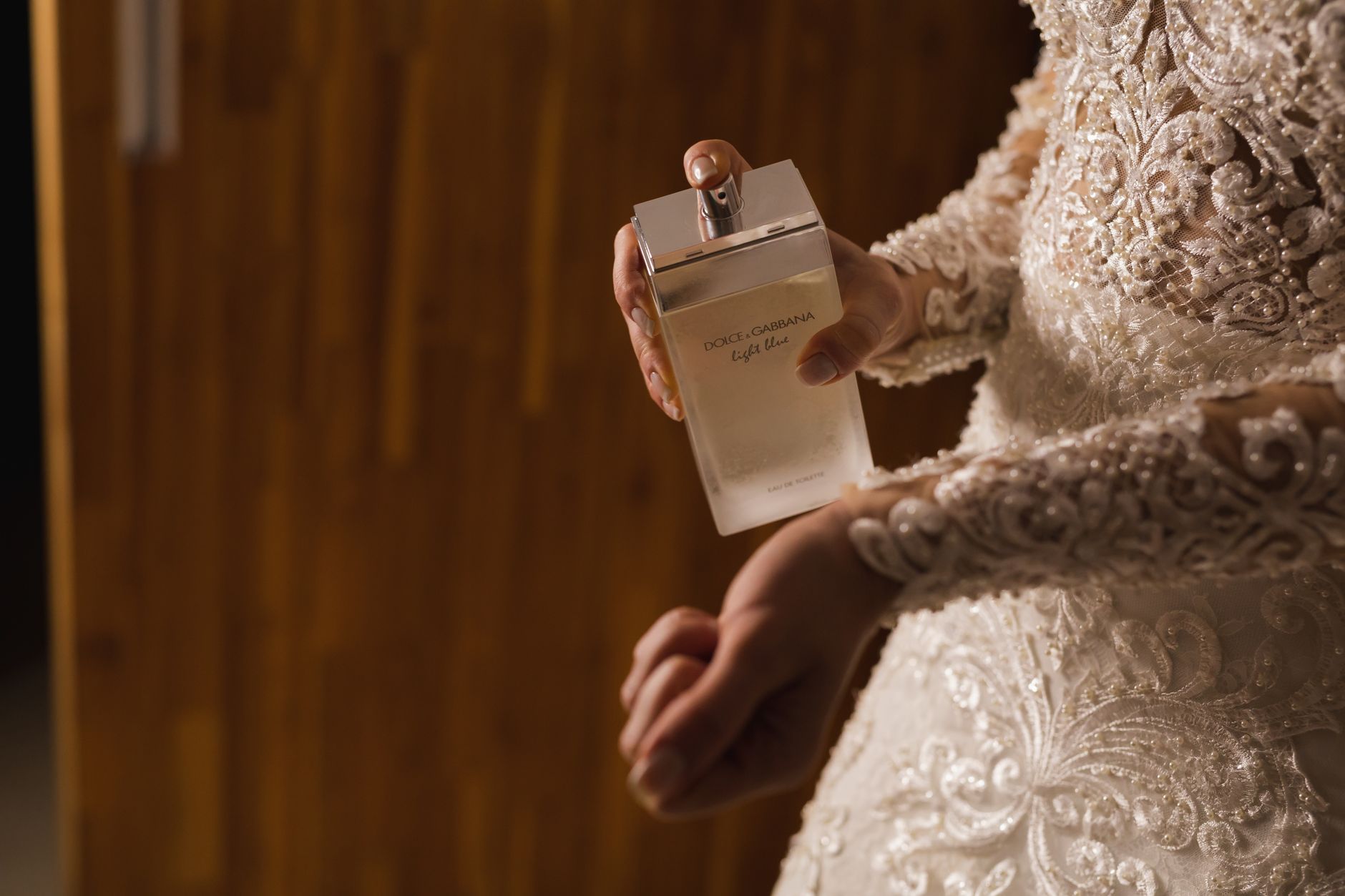 Bride in lace gown holding Dolce & Gabbana perfume, expressing elegance. — Big and delightful Women Internet Dating Sites - H