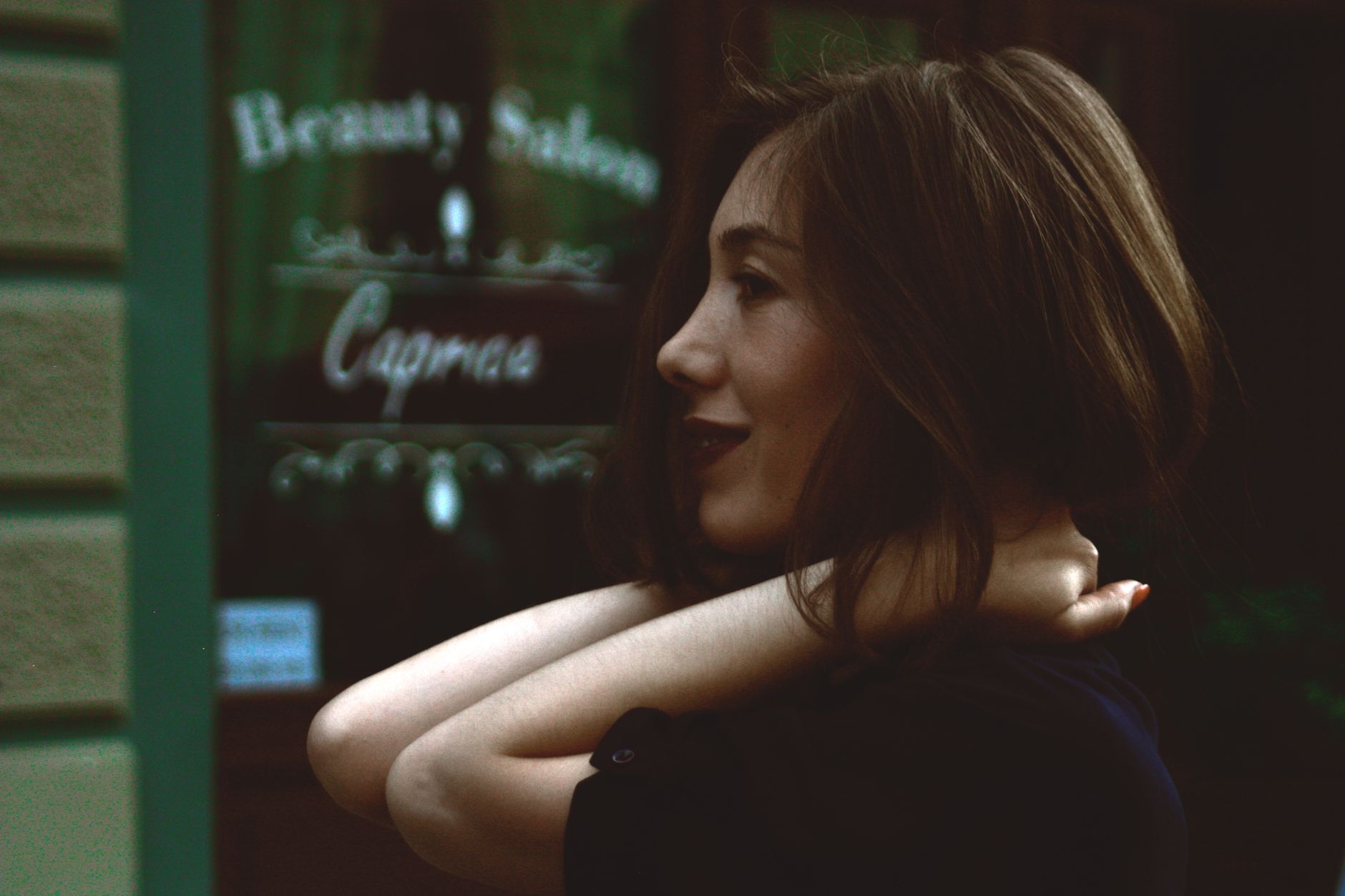 Side view of a smiling woman in front of a beauty salon, showcasing happiness and style. — Increase Your Beauty With Dark Win