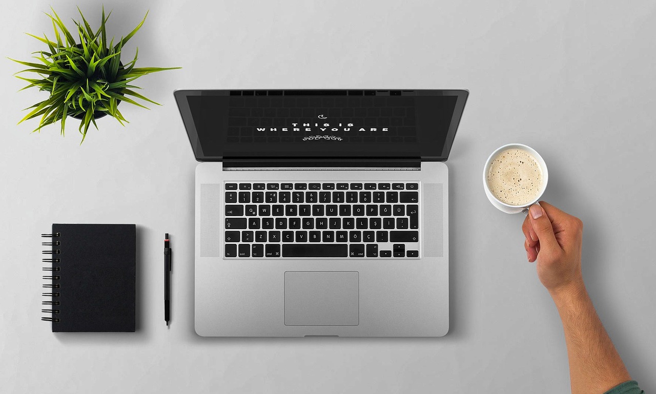 Laptop, coffee, arm — Top Considerations for Ethnic Rhinoplasty in the Heart of NYC
